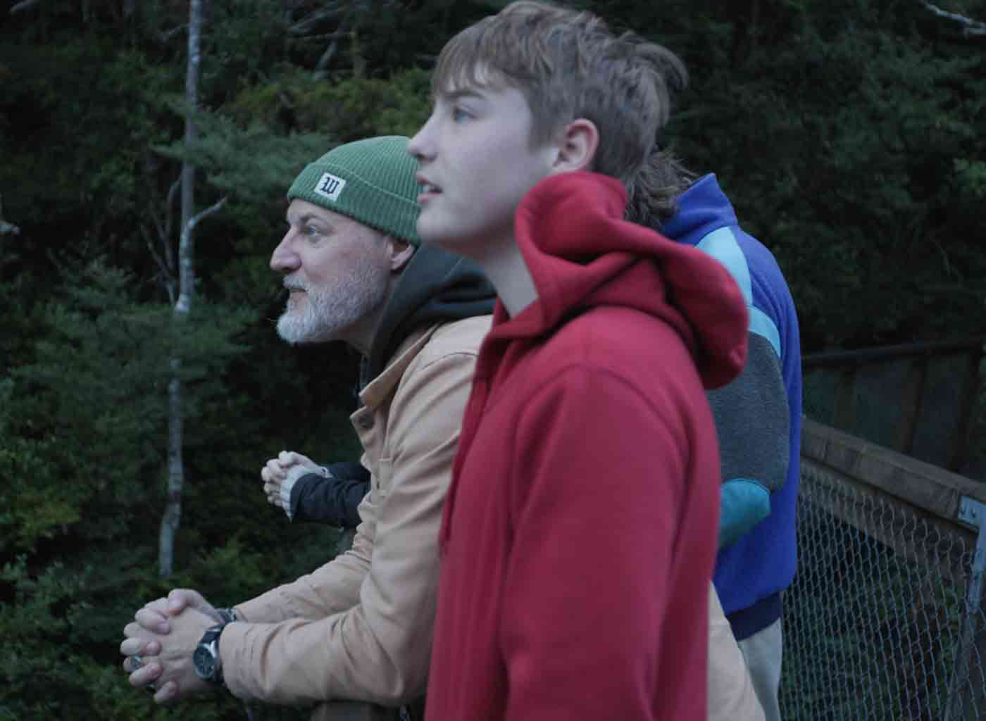 Father and sons taking in view from bridge